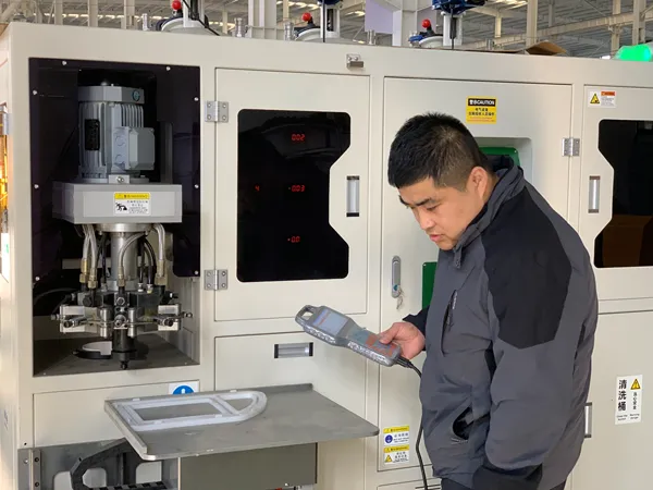 An operator is working beside the PU dispensing machine for air filters.
