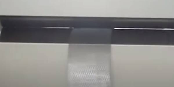 A machine is flattening expanded metal.