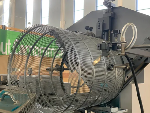 An automated spiral rolling machine producing heavy-duty truck air filter outer mesh.