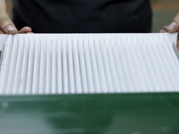 Worker assembling a manual cabin air filter.