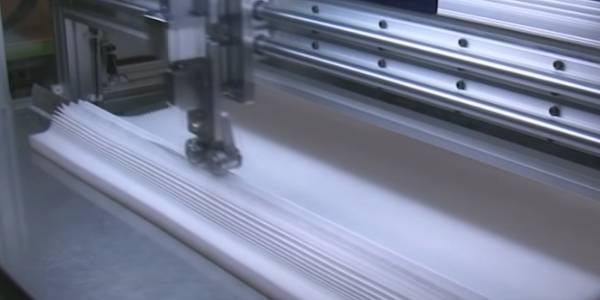 A machine is cutting non-woven filter cloth.