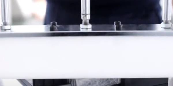 A machine is cutting filter into specific shapes.