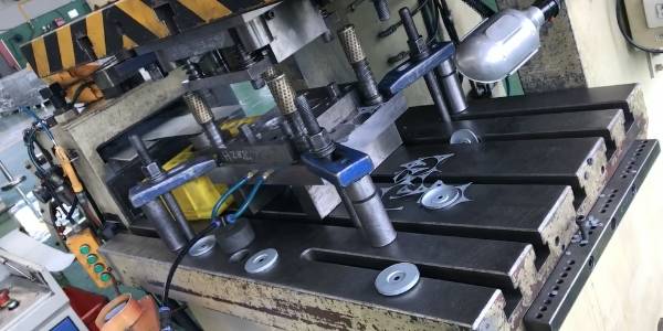 A machine is stamping end caps of spin-on filters.